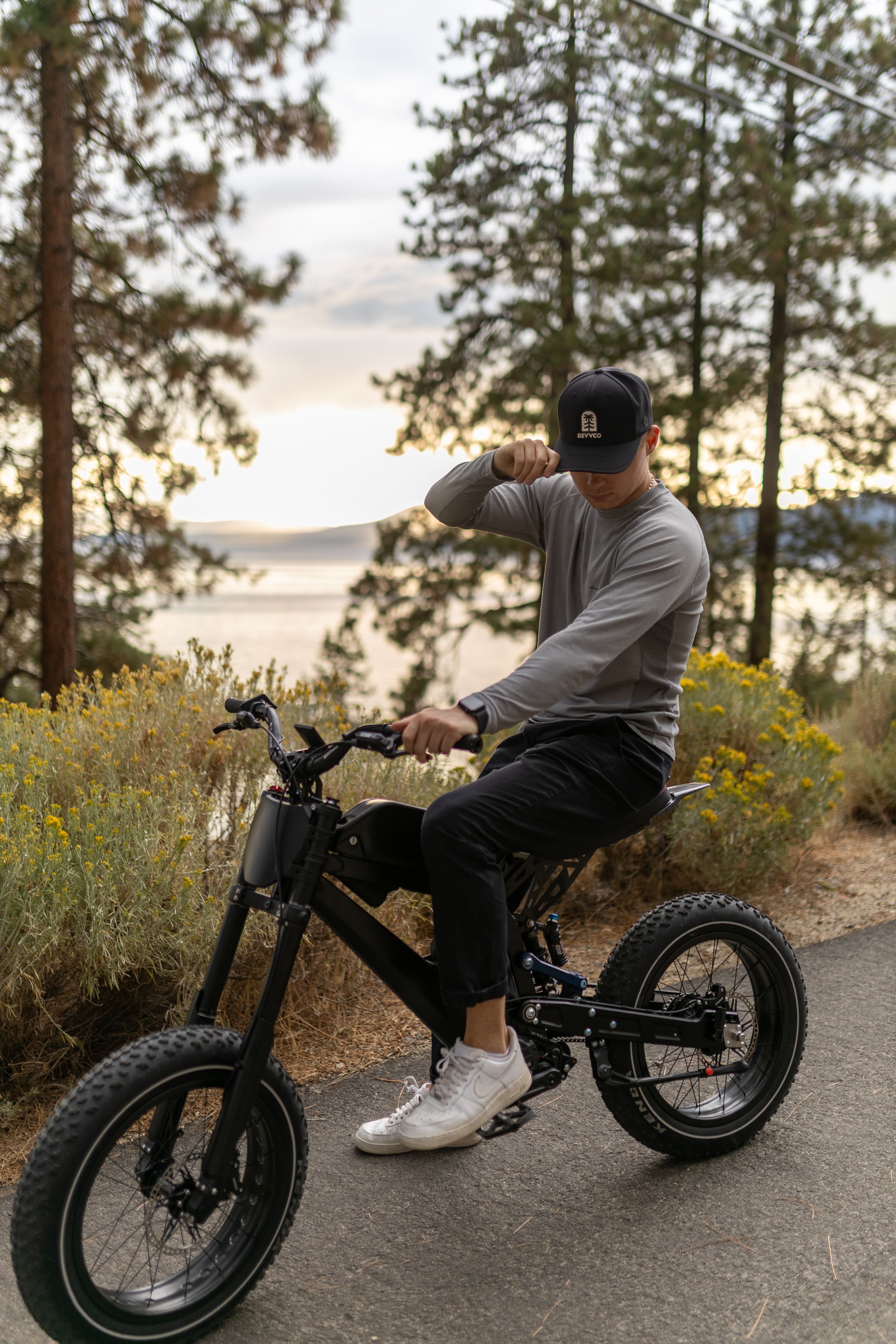 Surfline rider on a paved Tahoe road with trees in the background